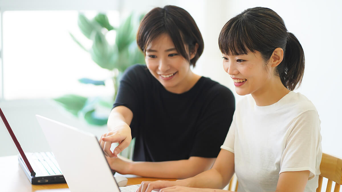 女性職員が利用者にパソコンの指導を行っている様子の画像