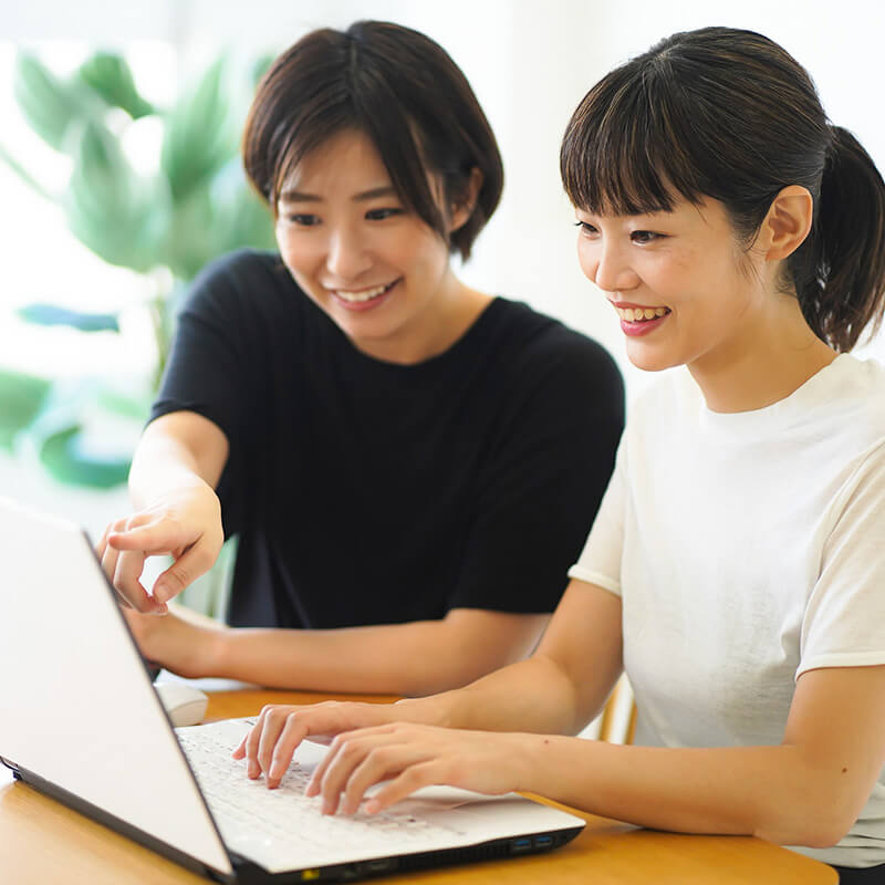 女性職員が利用者にパソコンの指導を行っている様子の画像